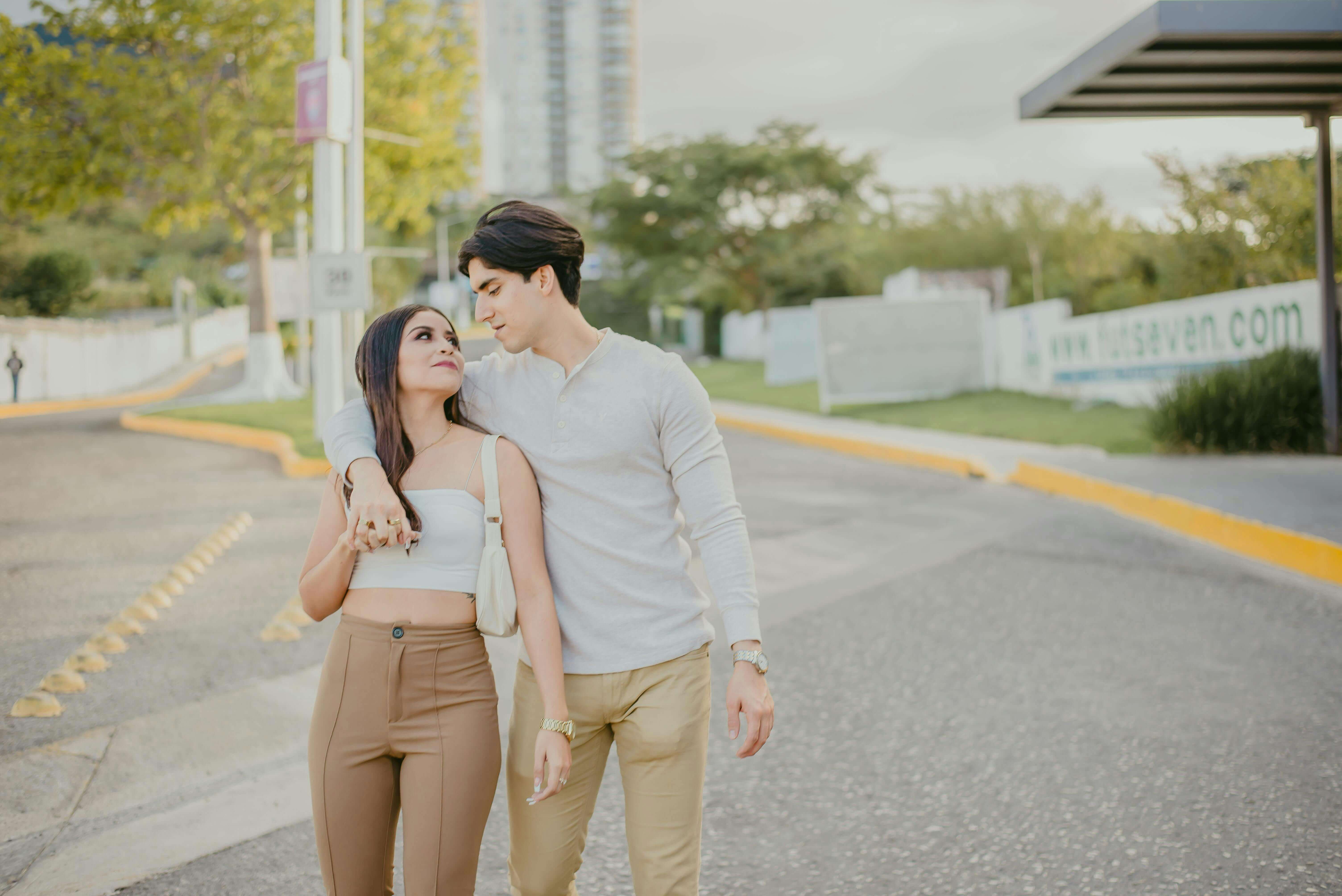 A young couple enjoying a sunny day outdoors, embracing each other lovingly.
