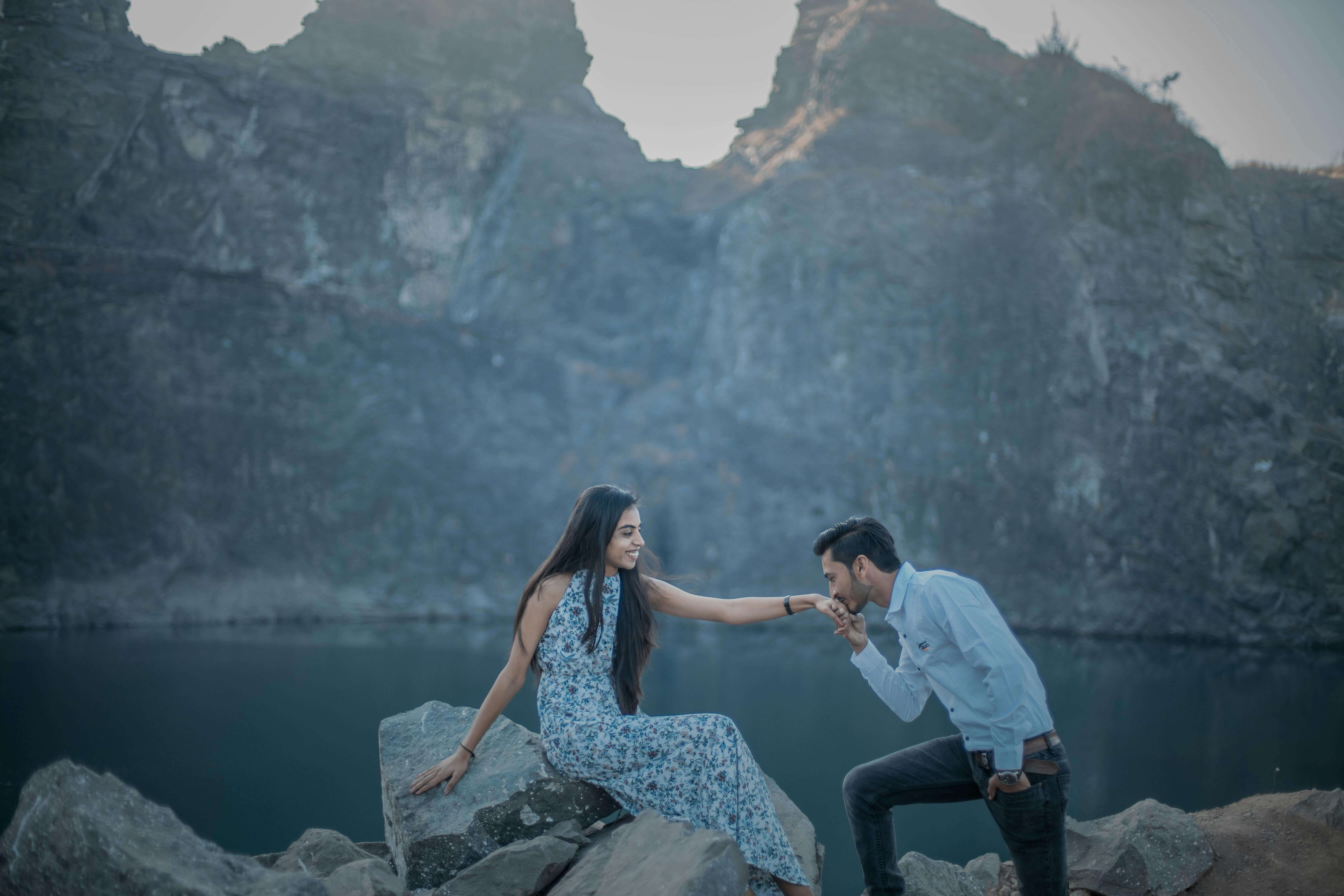 A couple sharing a romantic moment by a tranquil mountain lake.