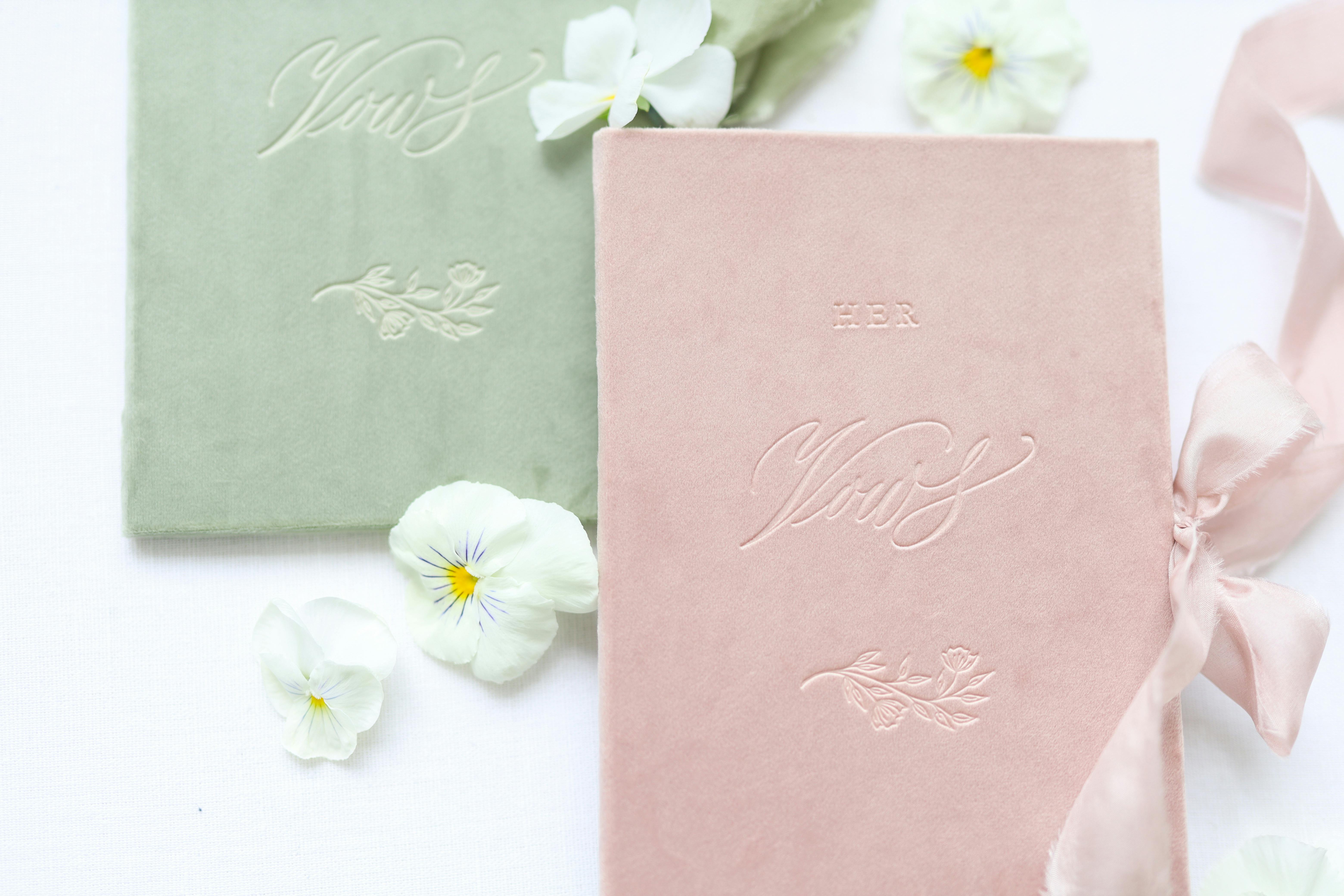 Pastel-colored wedding vows books with delicate floral decorations. Perfect marriage keepsake.