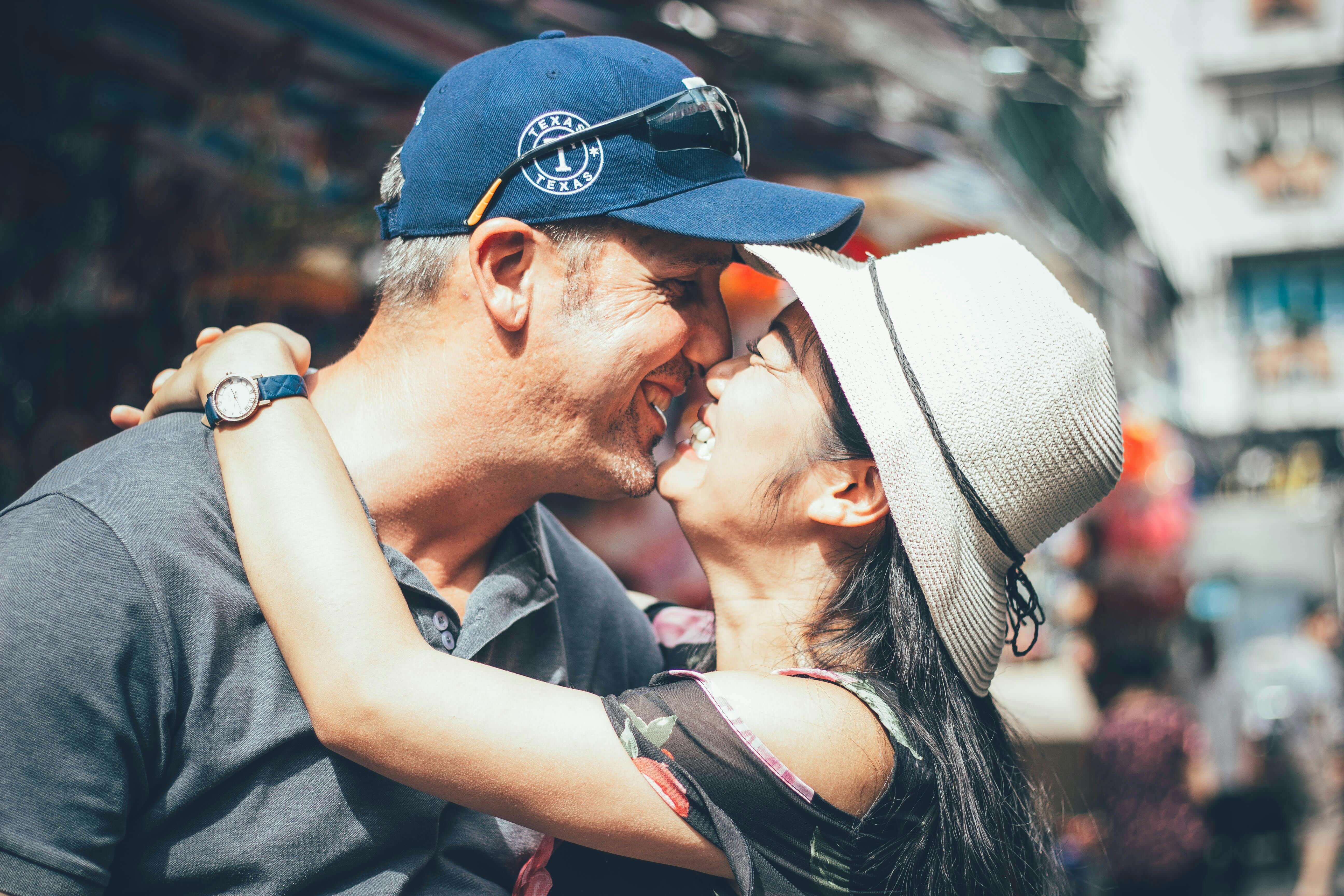 A joyful couple shares an embrace under a clear sky, capturing love and happiness outdoors.