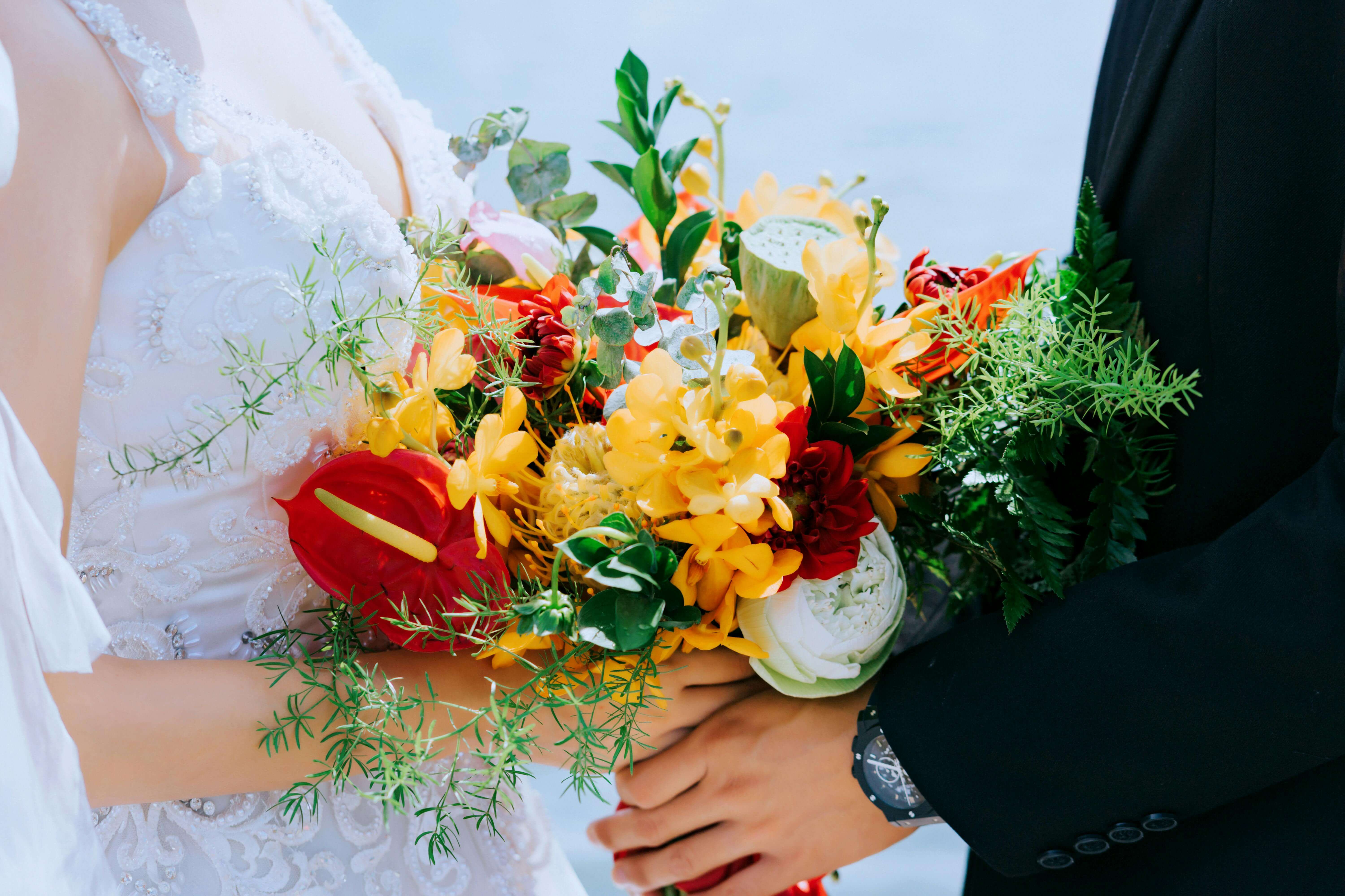 Close-up of a wedding couple holding a vibrant bouquet in ÄÃ  Láº¡t, Vietnam.
