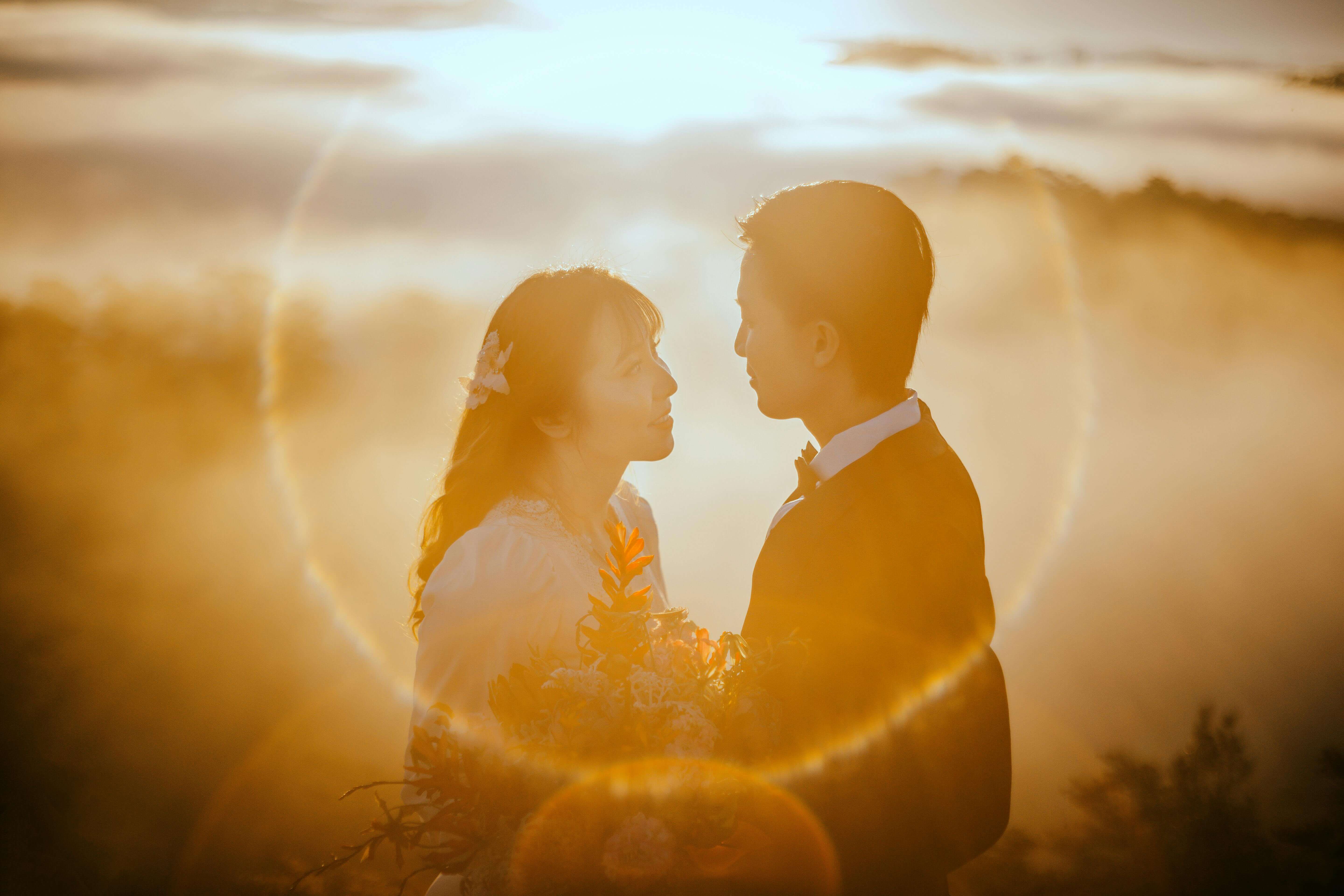 A romantic couple embraces with the sunset in the background, creating a magical wedding moment.