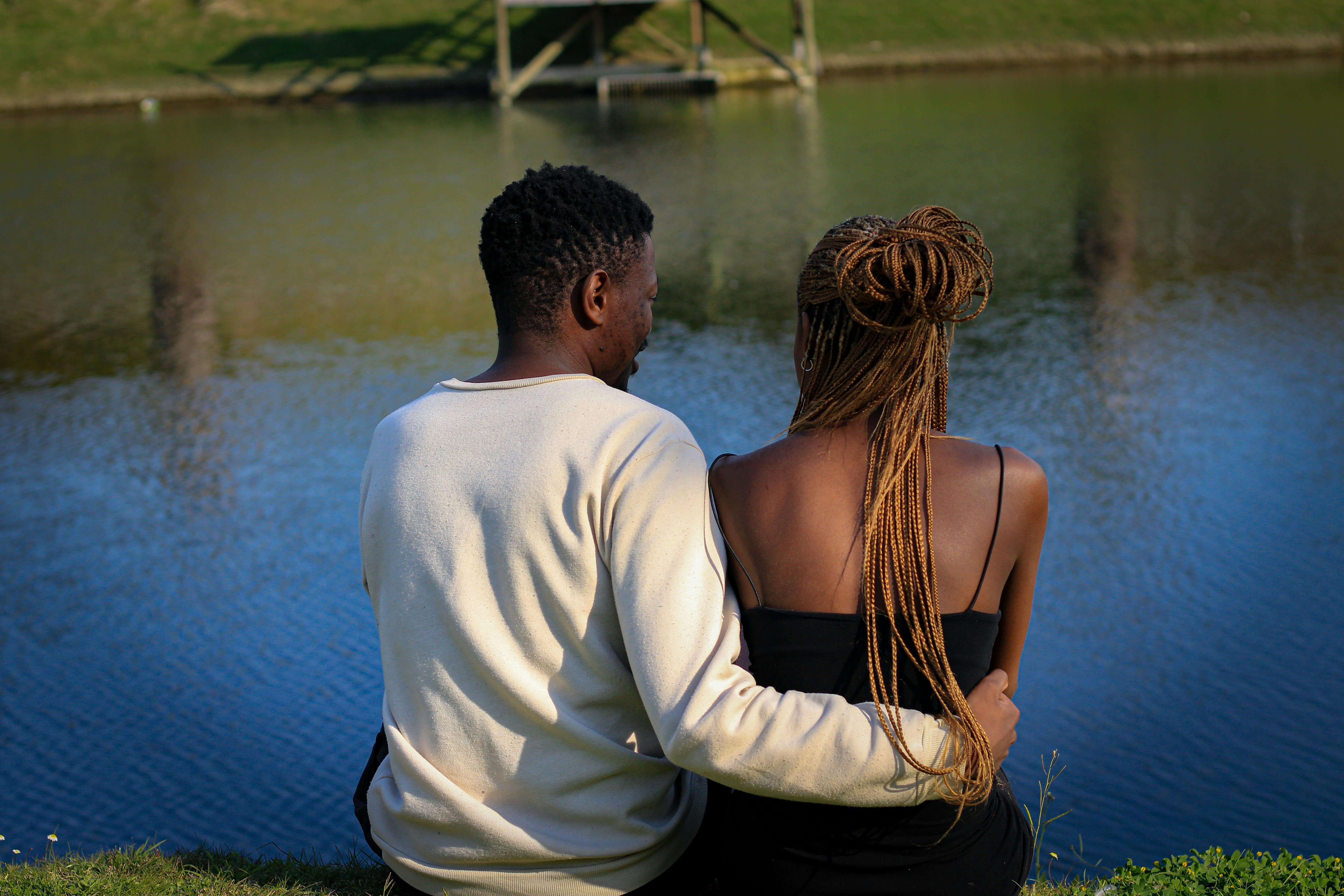 A couple enjoys a peaceful moment by the lake, highlighting love and companionship.