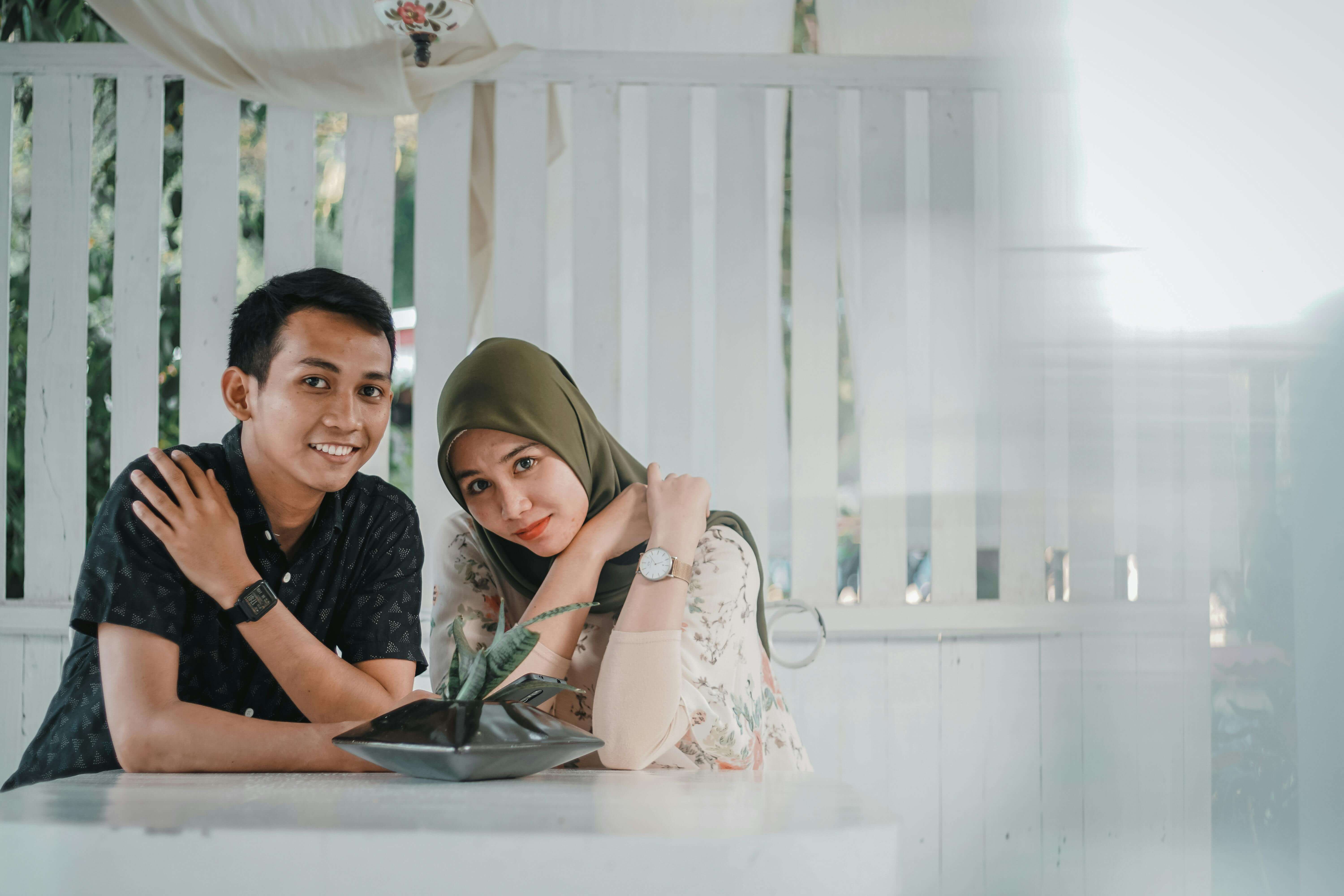 A couple sits together in a cozy, modern setting, showcasing love and togetherness.