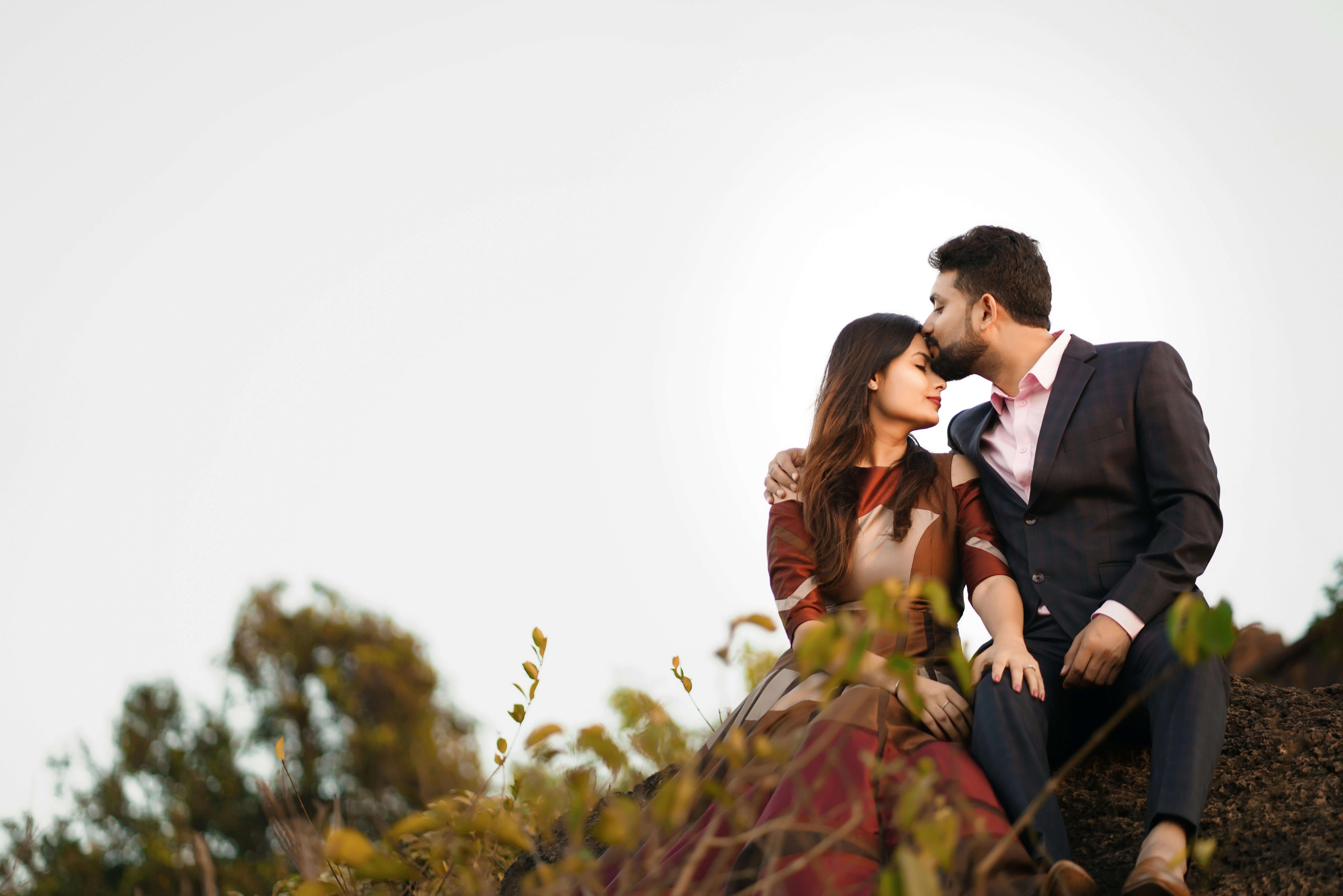 A romantic pre-wedding photoshoot of an Indian couple embracing outdoors.