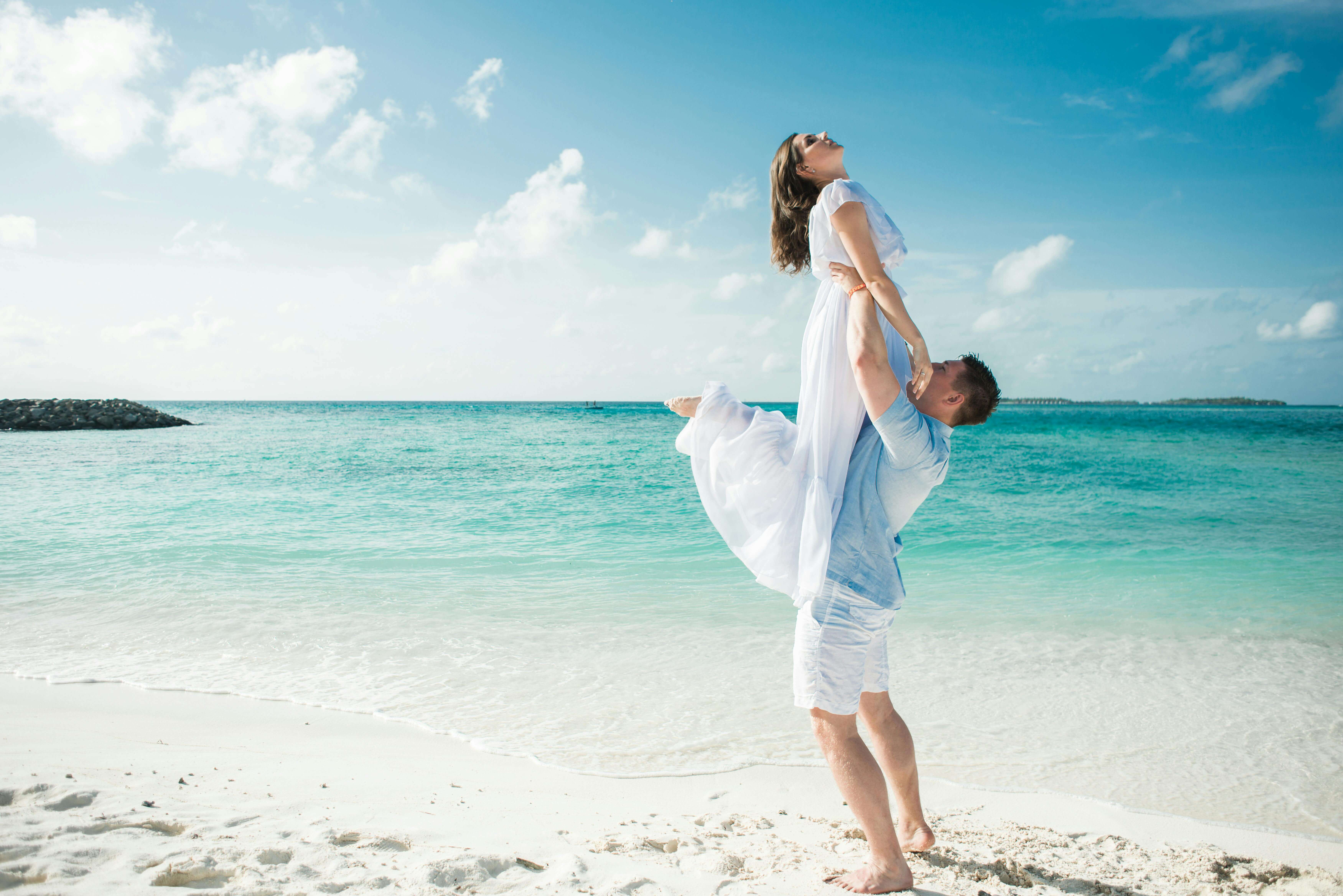 A couple enjoying a fun and romantic moment on a beautiful tropical beach.