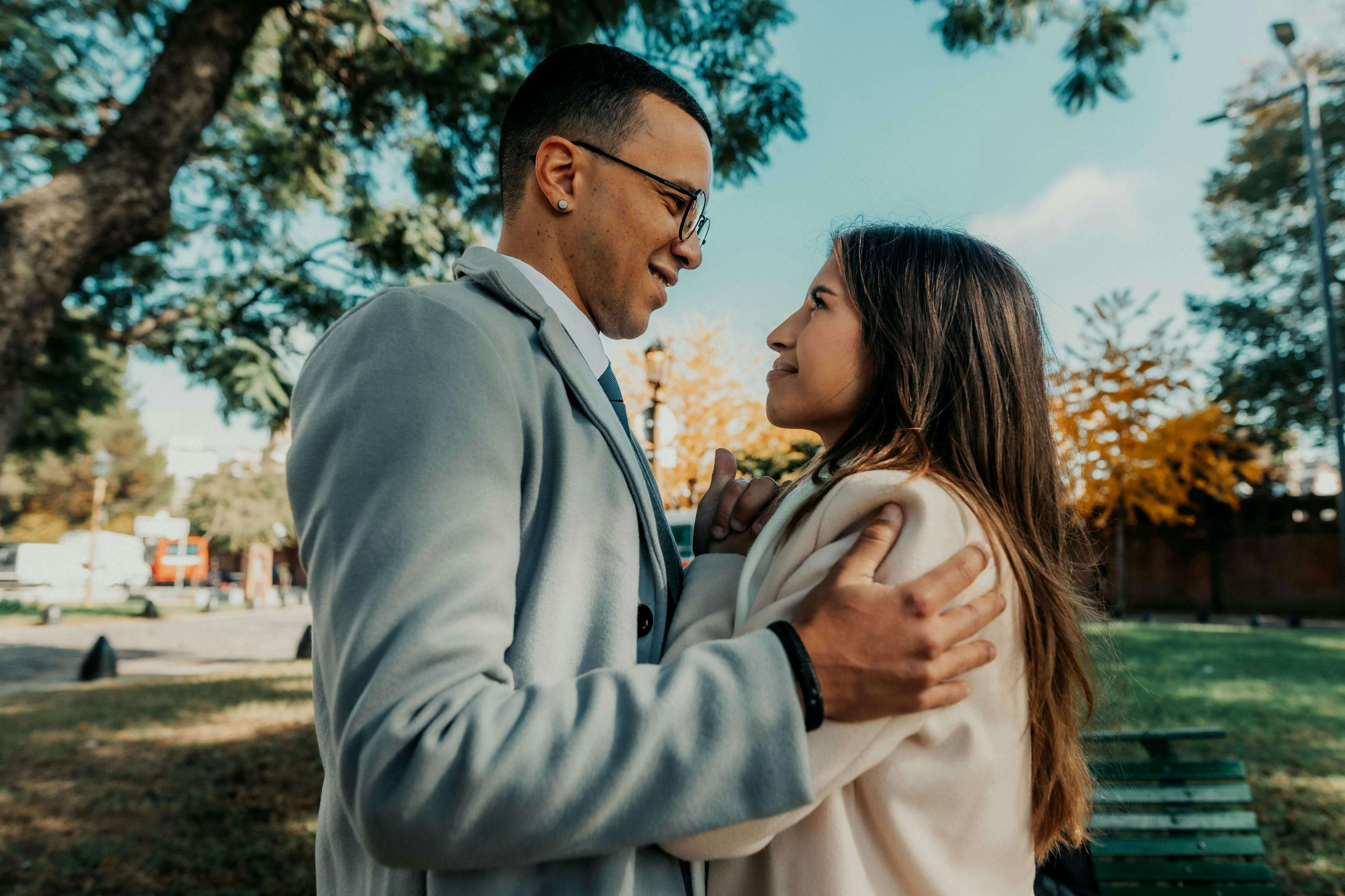 A couple shares a tender moment in a park in Buenos Aires, Argentina, during the fall.