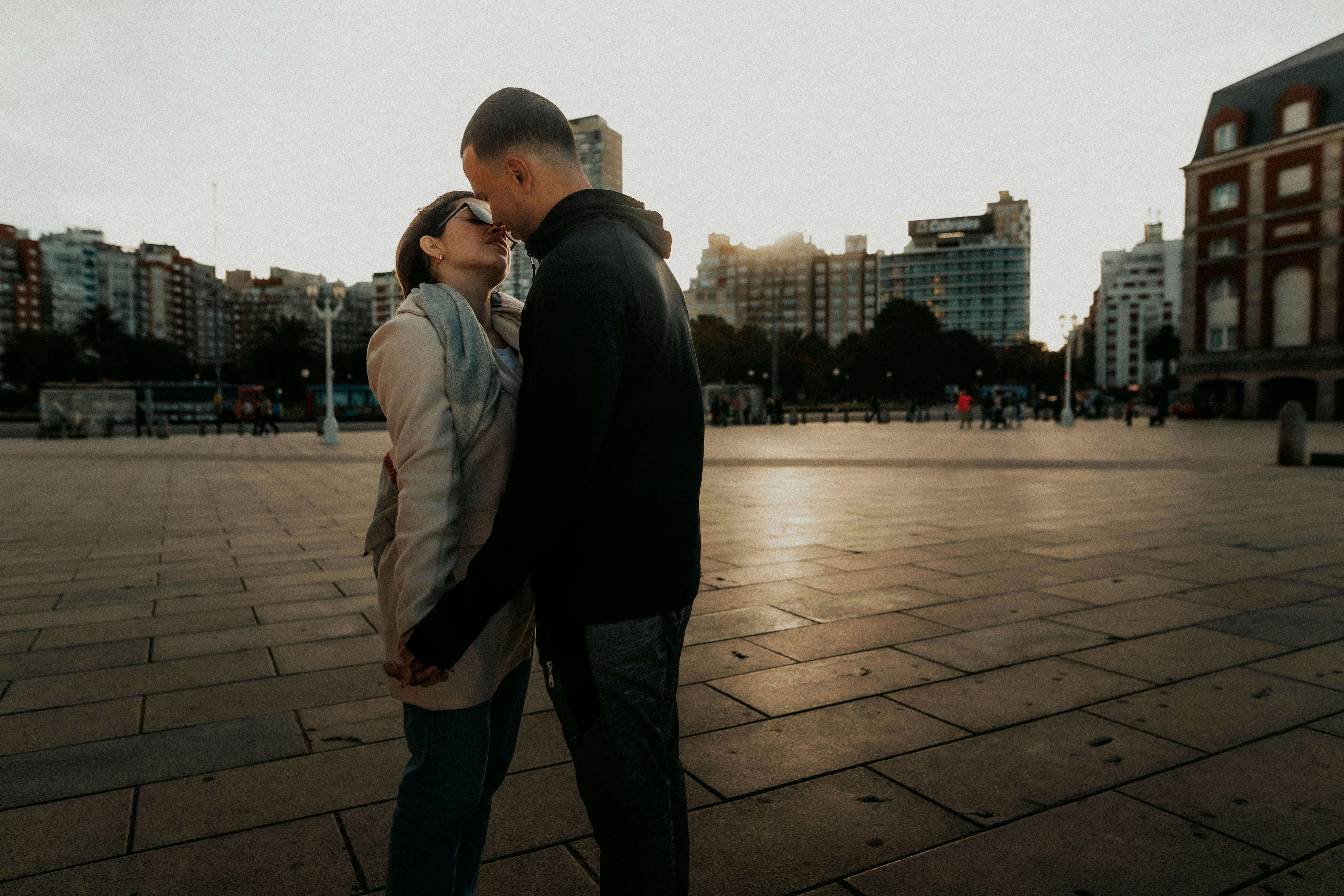 A couple embraces at sunset in Mar del Plata, showcasing love and connection.
