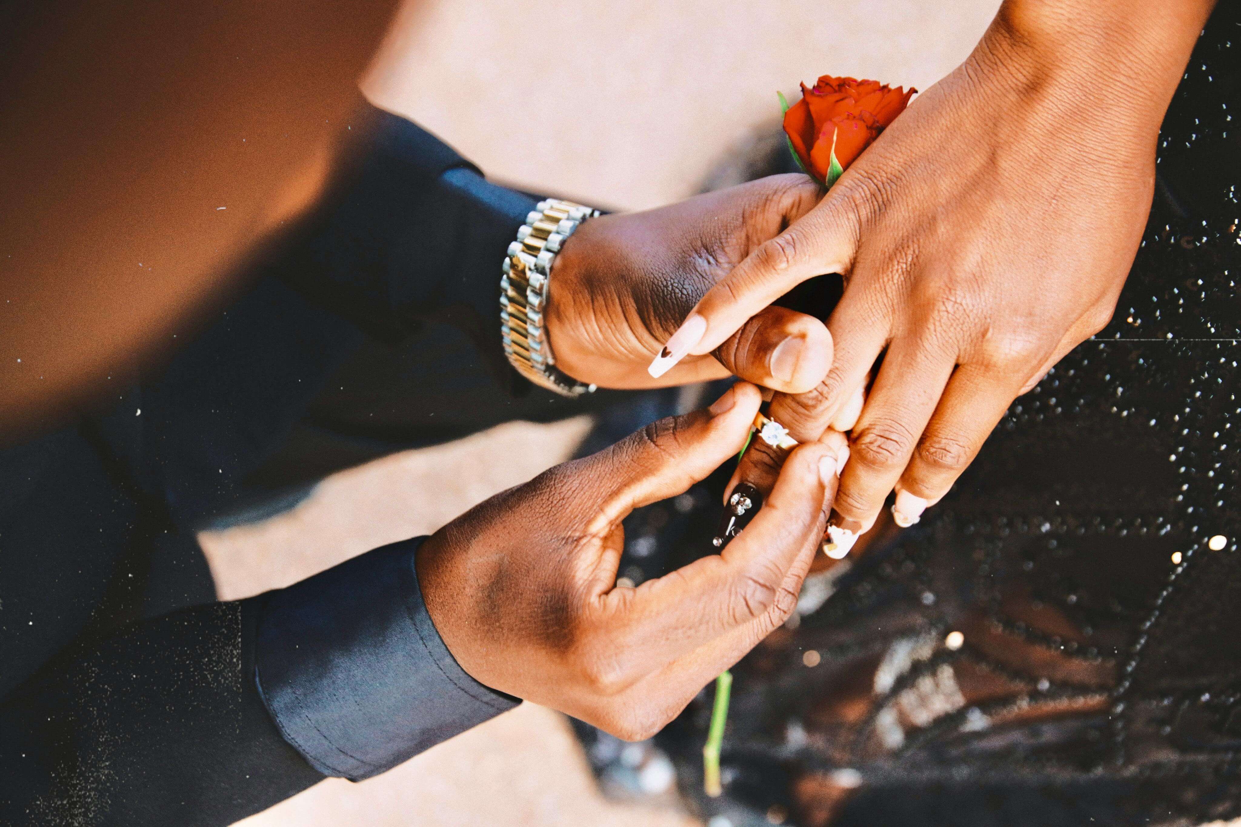 Close-up of a romantic engagement ring proposal with a red rose, capturing heartfelt emotion.