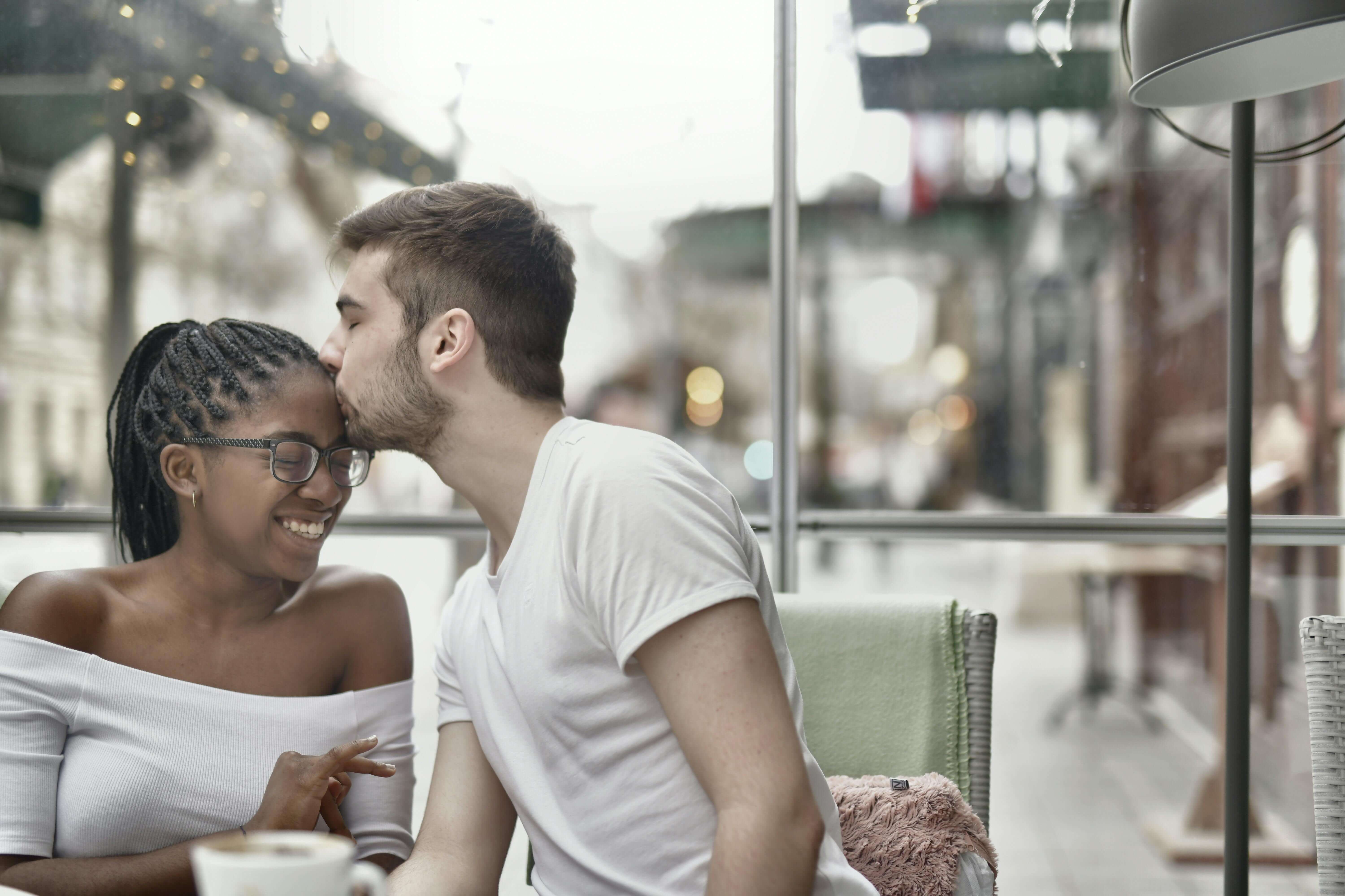Happy couple enjoying a loving moment in a cozy cafe setting.