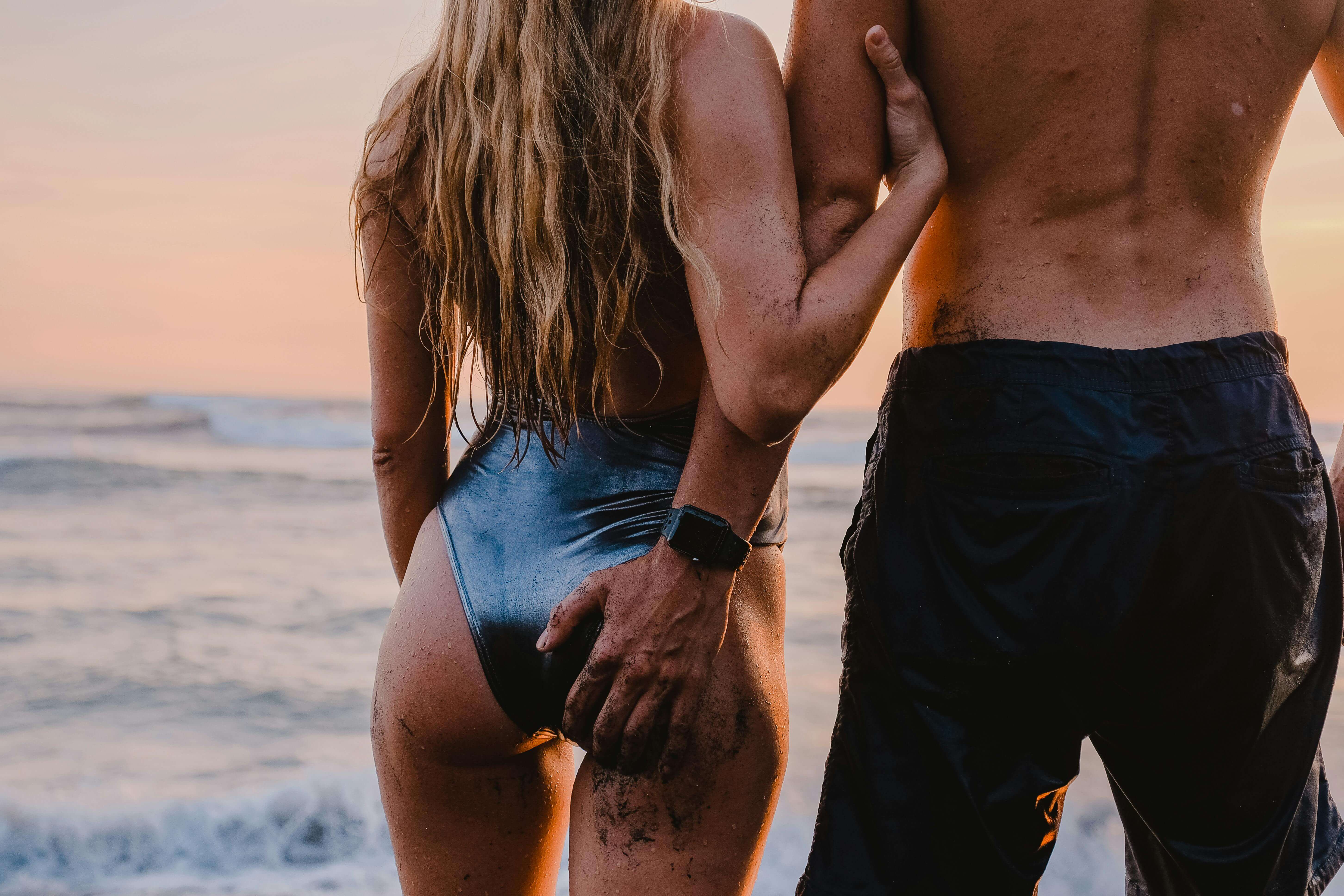 A couple embraces on the beach during a warm sunset, embodying romance and connection.