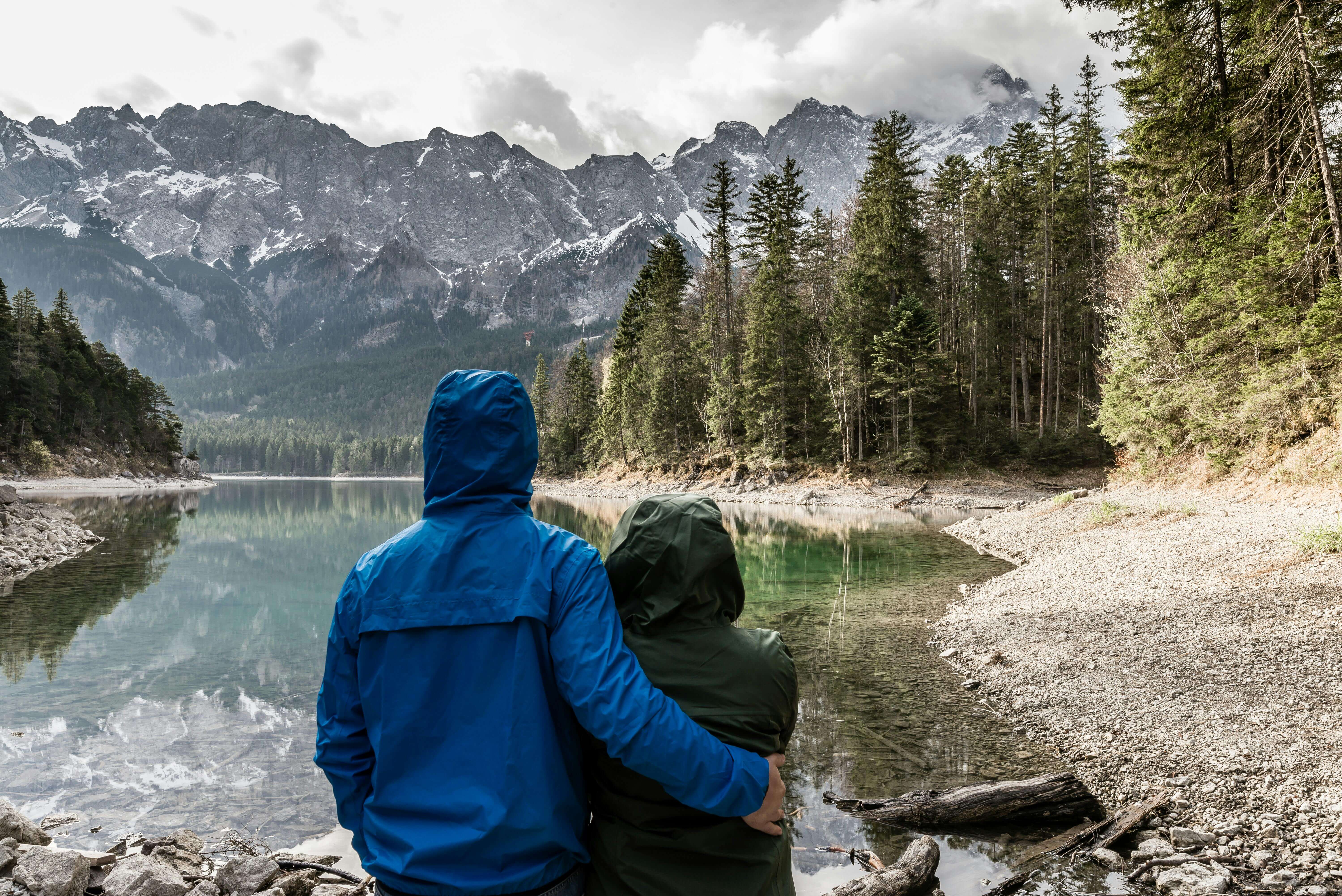Romantic couple hugging and admiring the view of a mountain lake in Grainau, Germany.