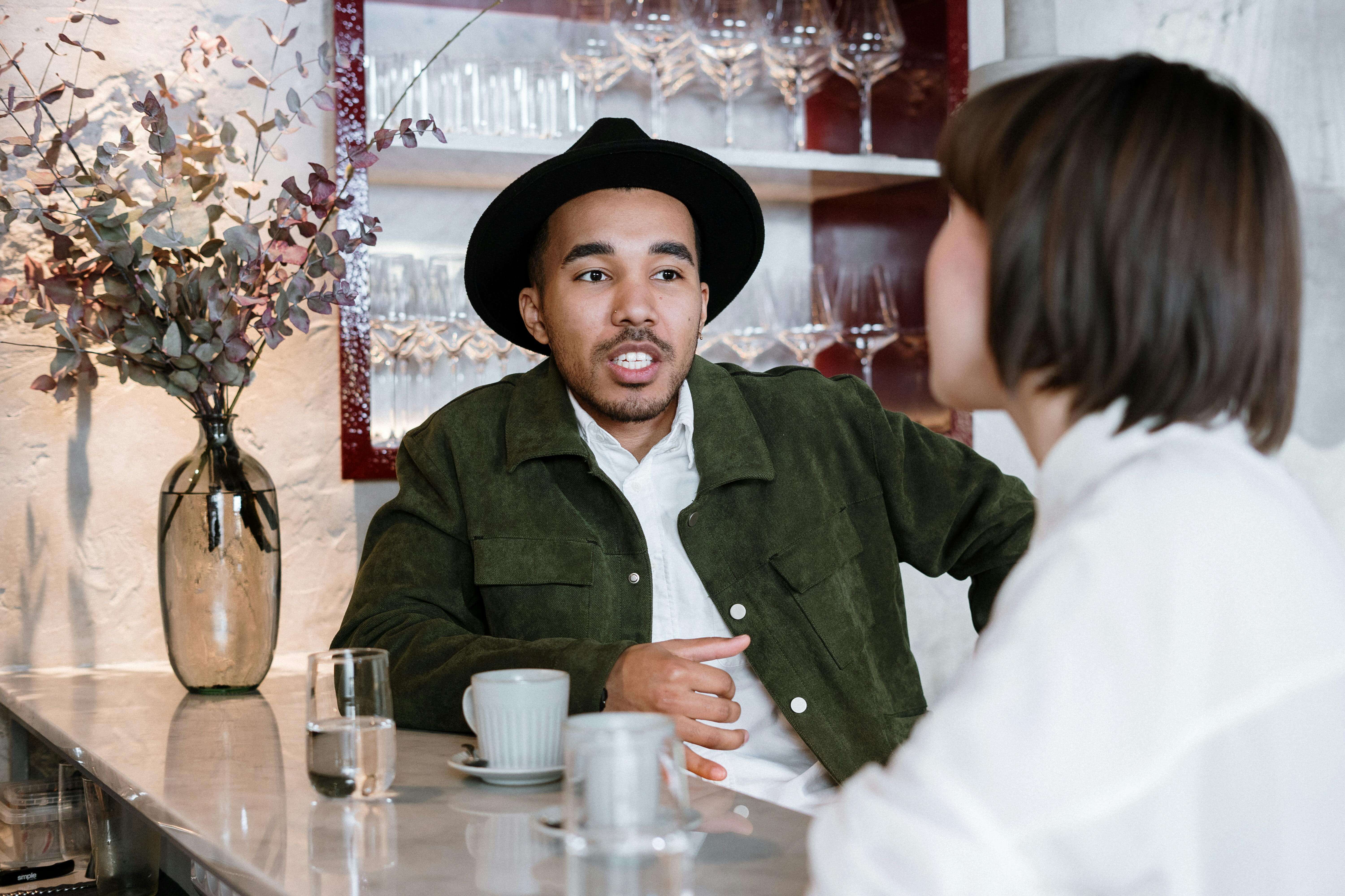 A couple enjoying a relaxed conversation in a stylish cafÃÂ© bar setting.