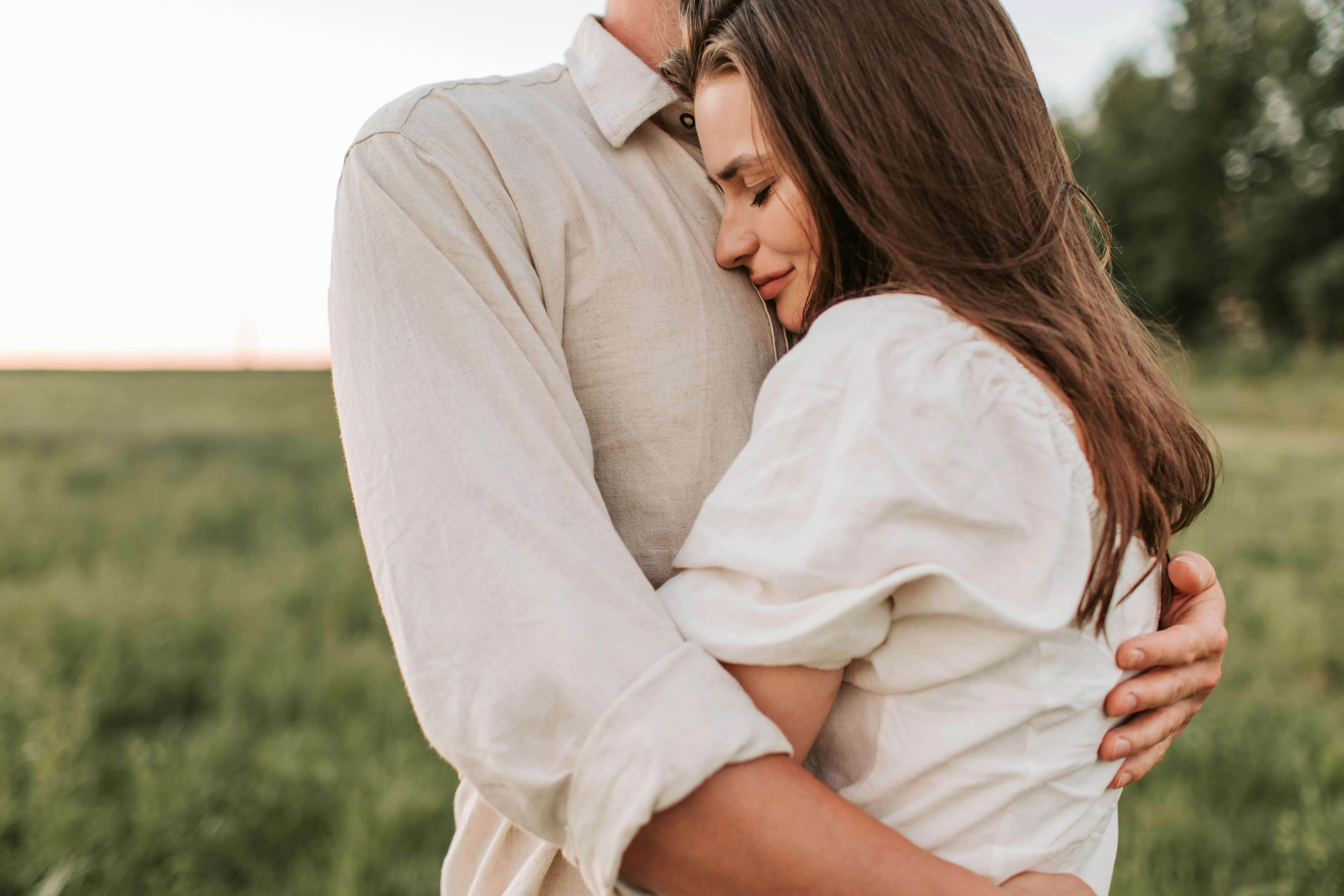 A romantic embrace between a couple outdoors at sunset, showcasing love and connection.