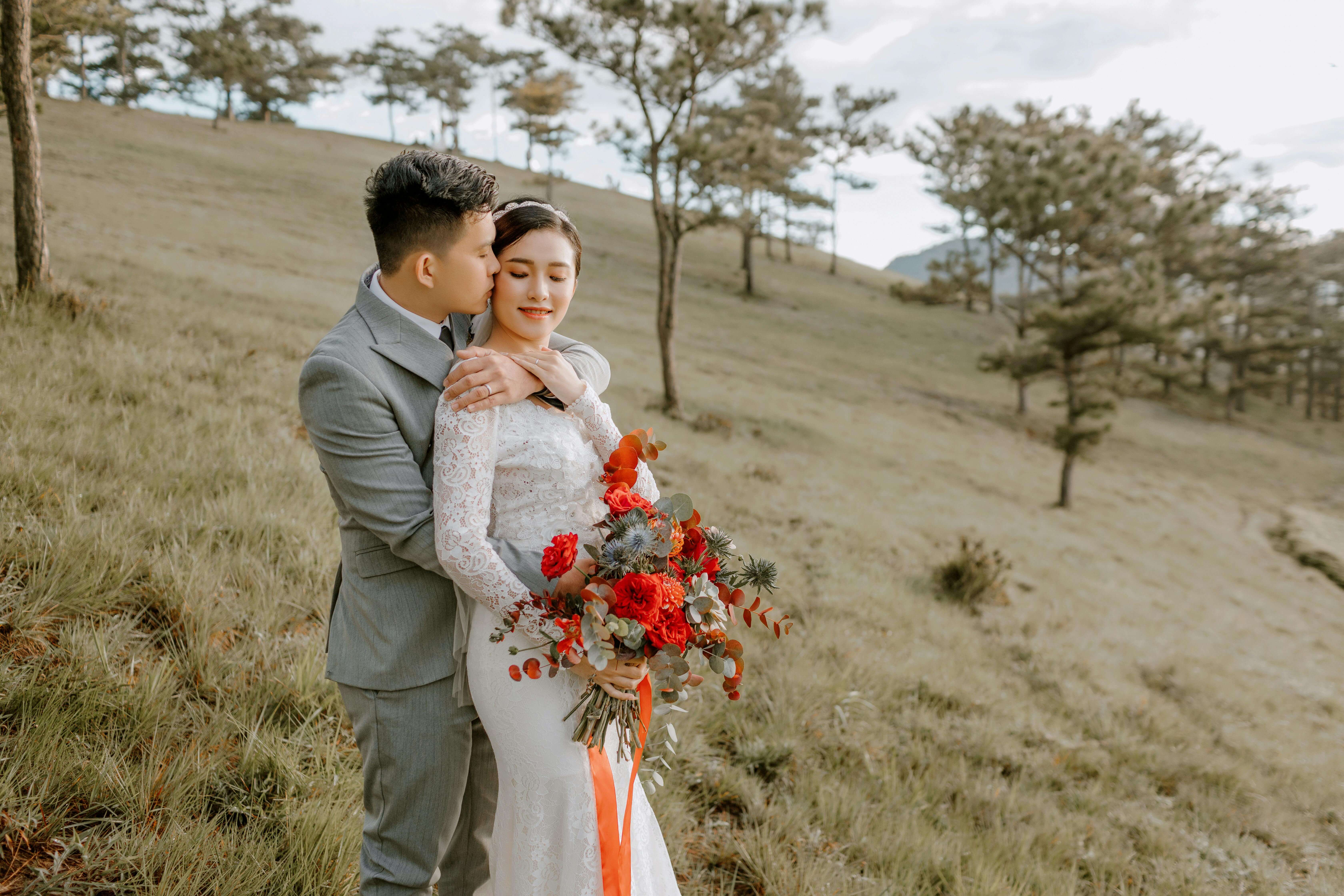 A couple embraces outdoors with a vibrant bouquet, perfect for romantic themes.