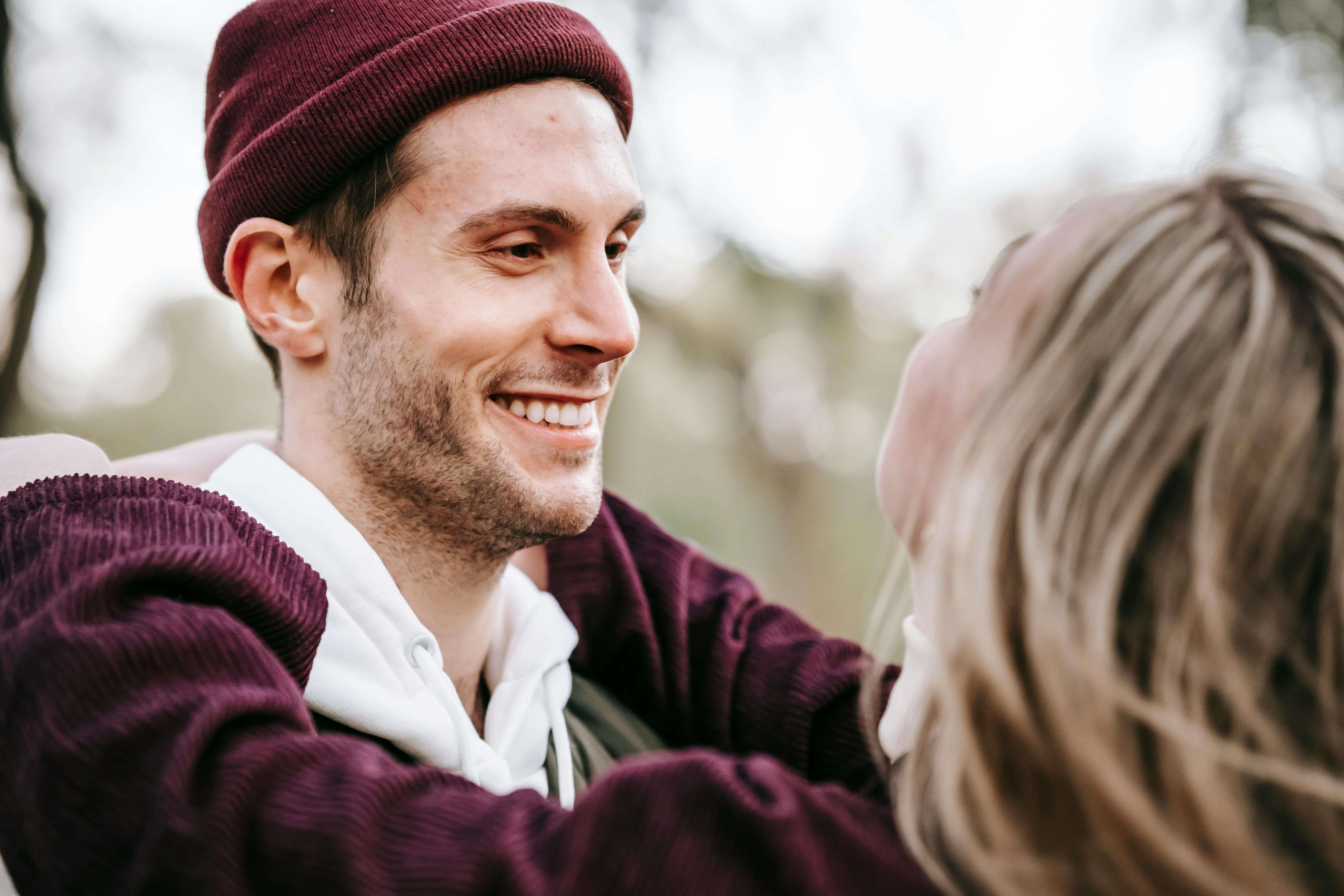 Happy couple embracing outdoors, showcasing love and warmth in a park setting.