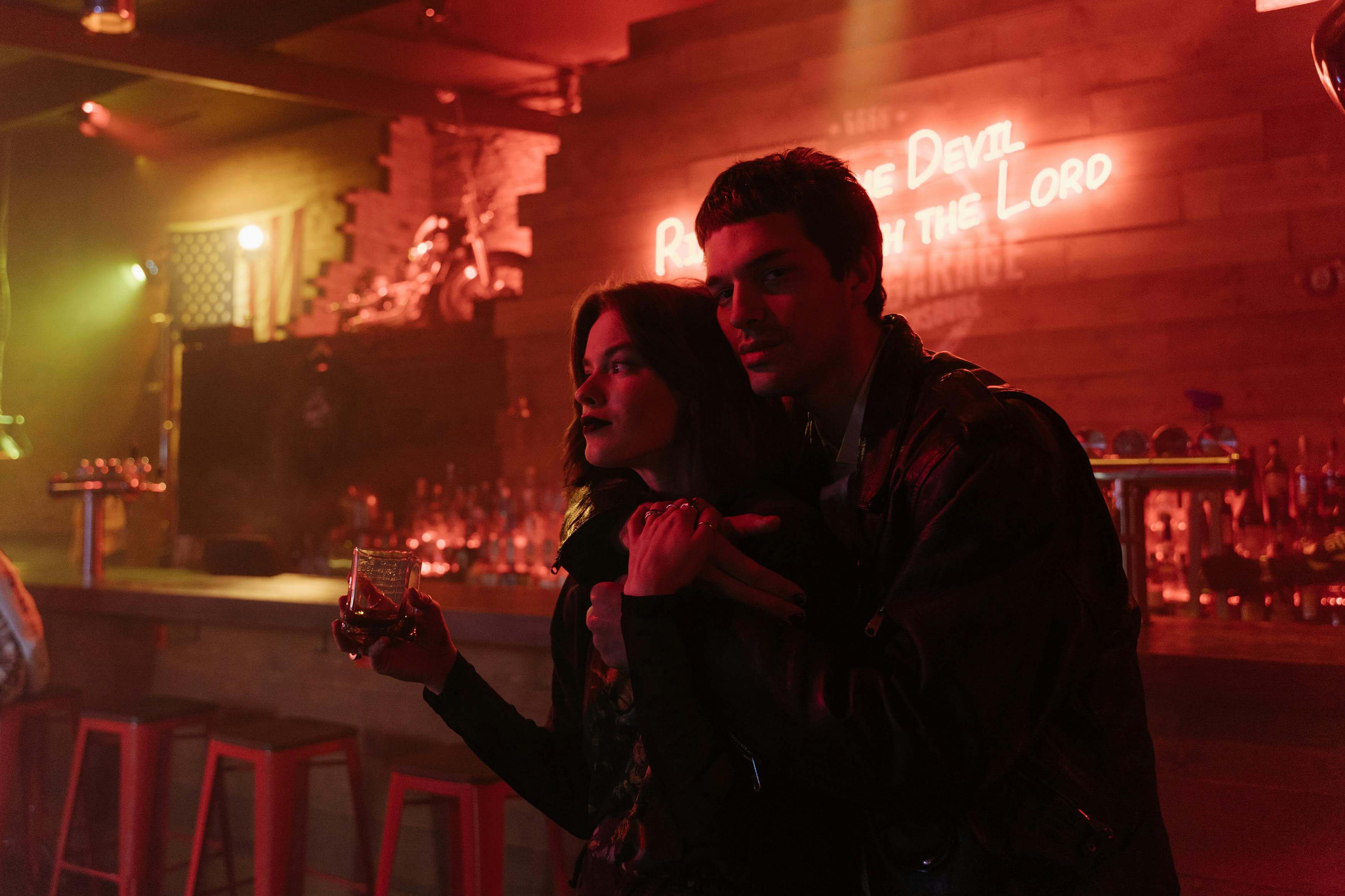 A couple enjoys a drink at a dimly lit bar, creating a romantic and intimate vibe.