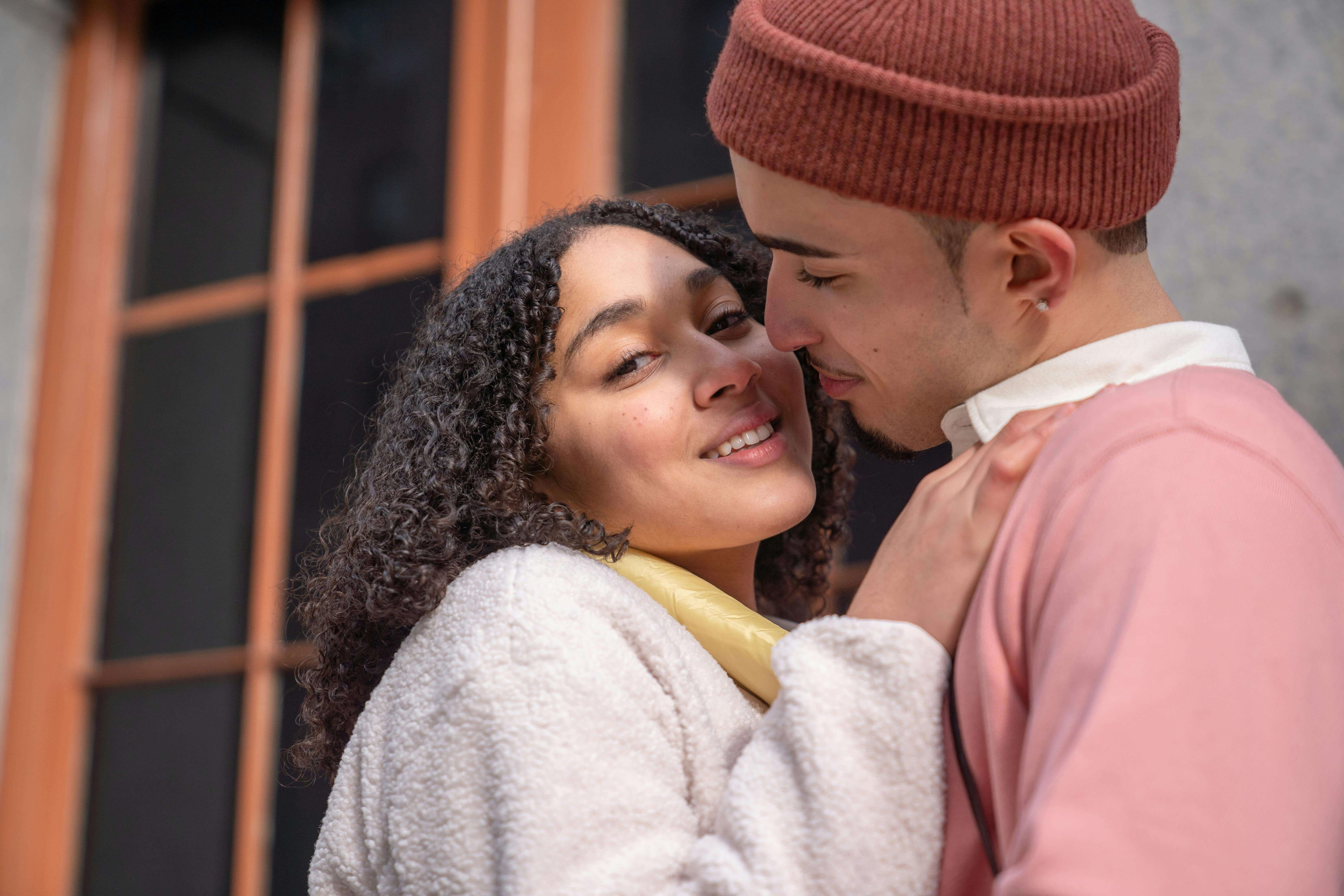 A loving young couple shares a warm, tender moment outside, radiating happiness and connection.