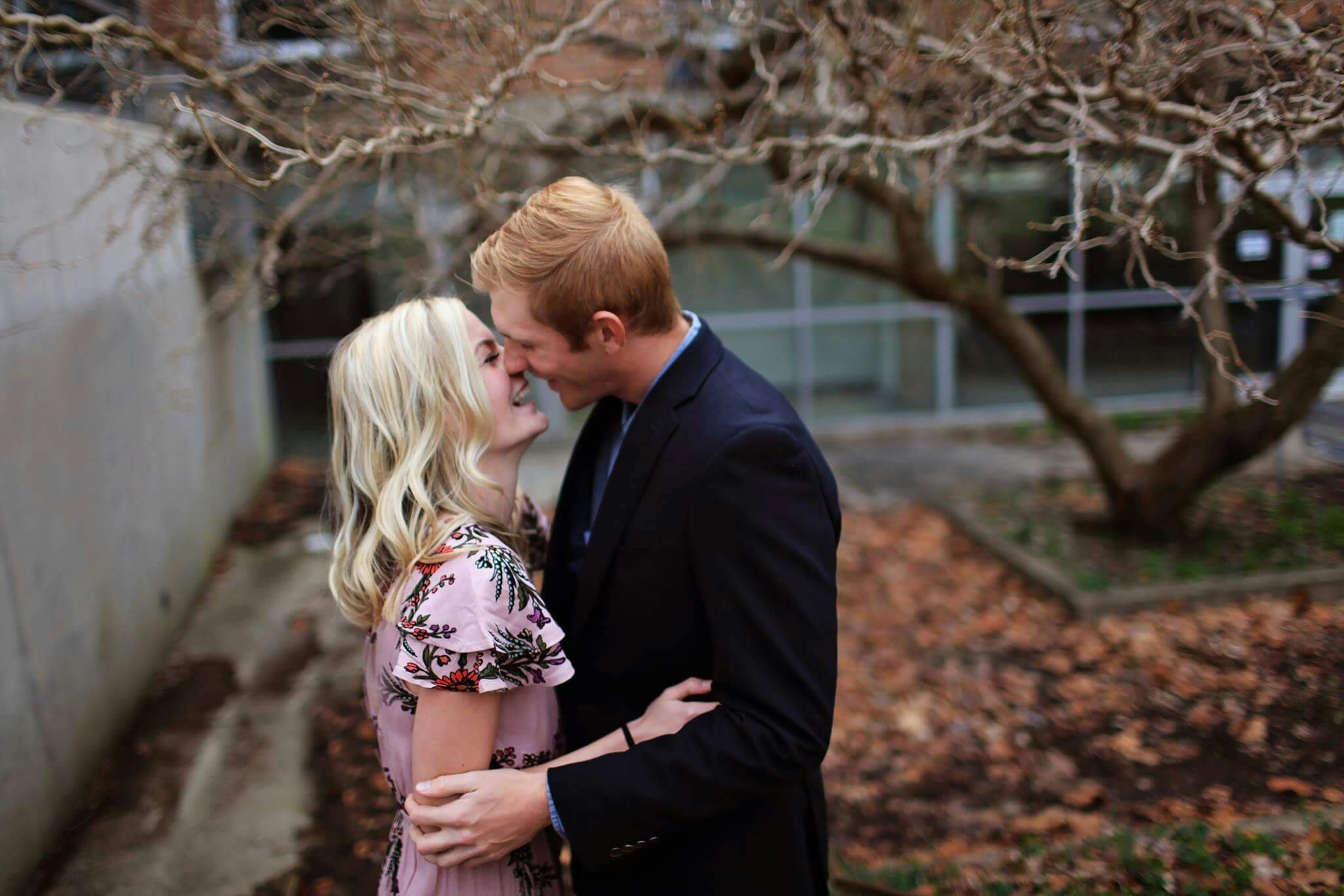 A young couple sharing a romantic moment amidst autumn leaves, capturing love and joy outdoors.