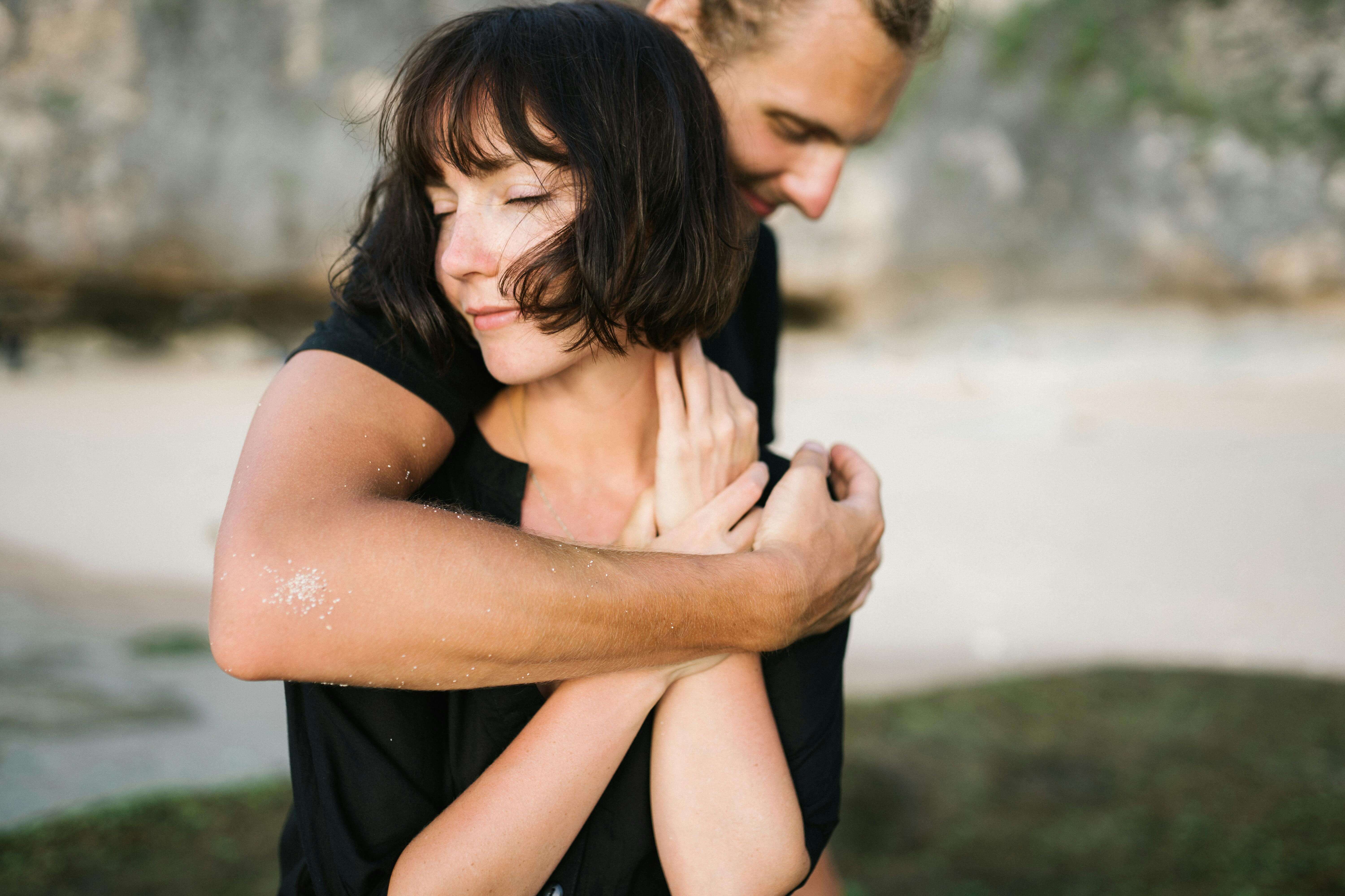 A couple embracing lovingly on a serene beach, capturing a moment of romance and connection.