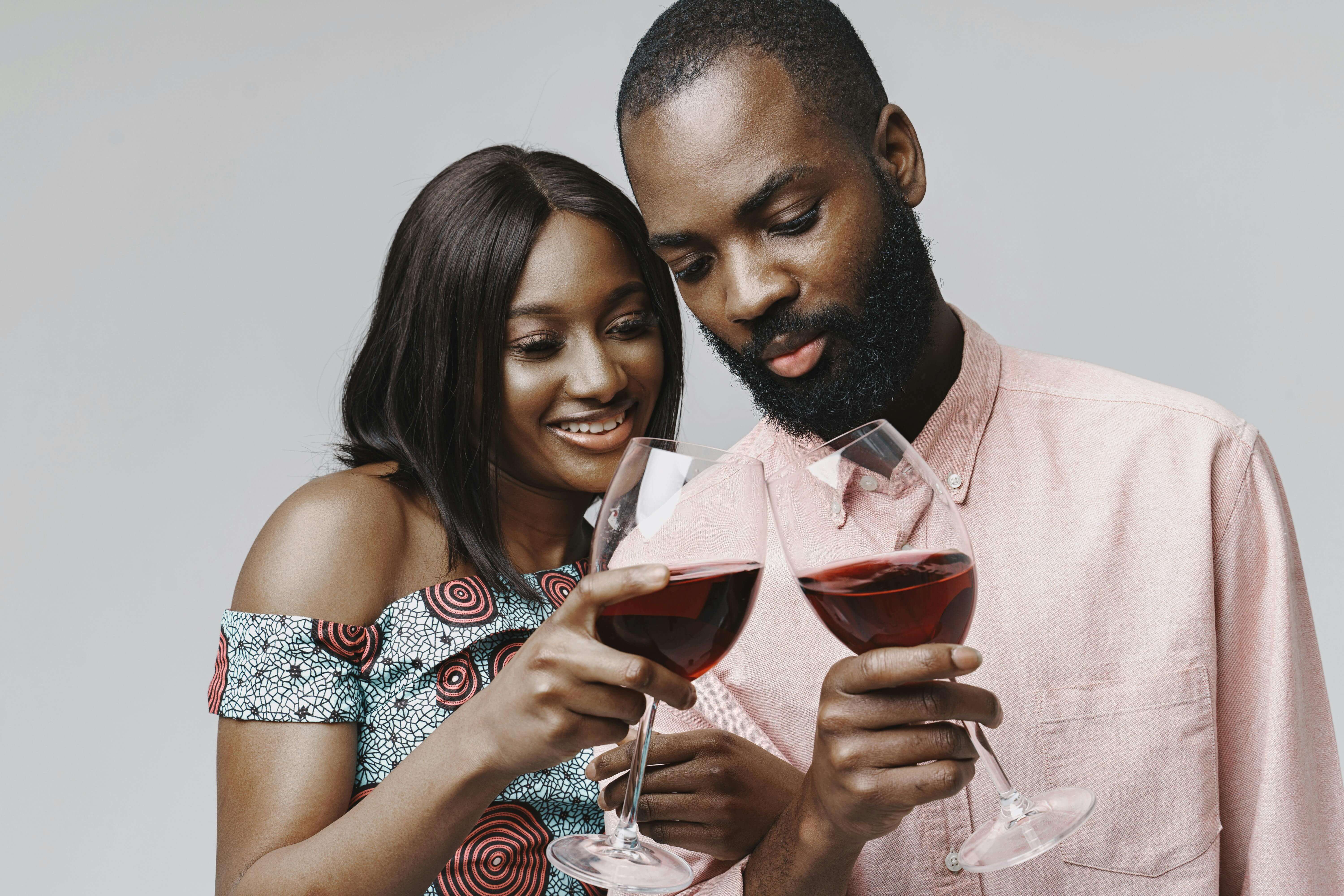 A joyful African American couple toasting with red wine, capturing love and celebration.