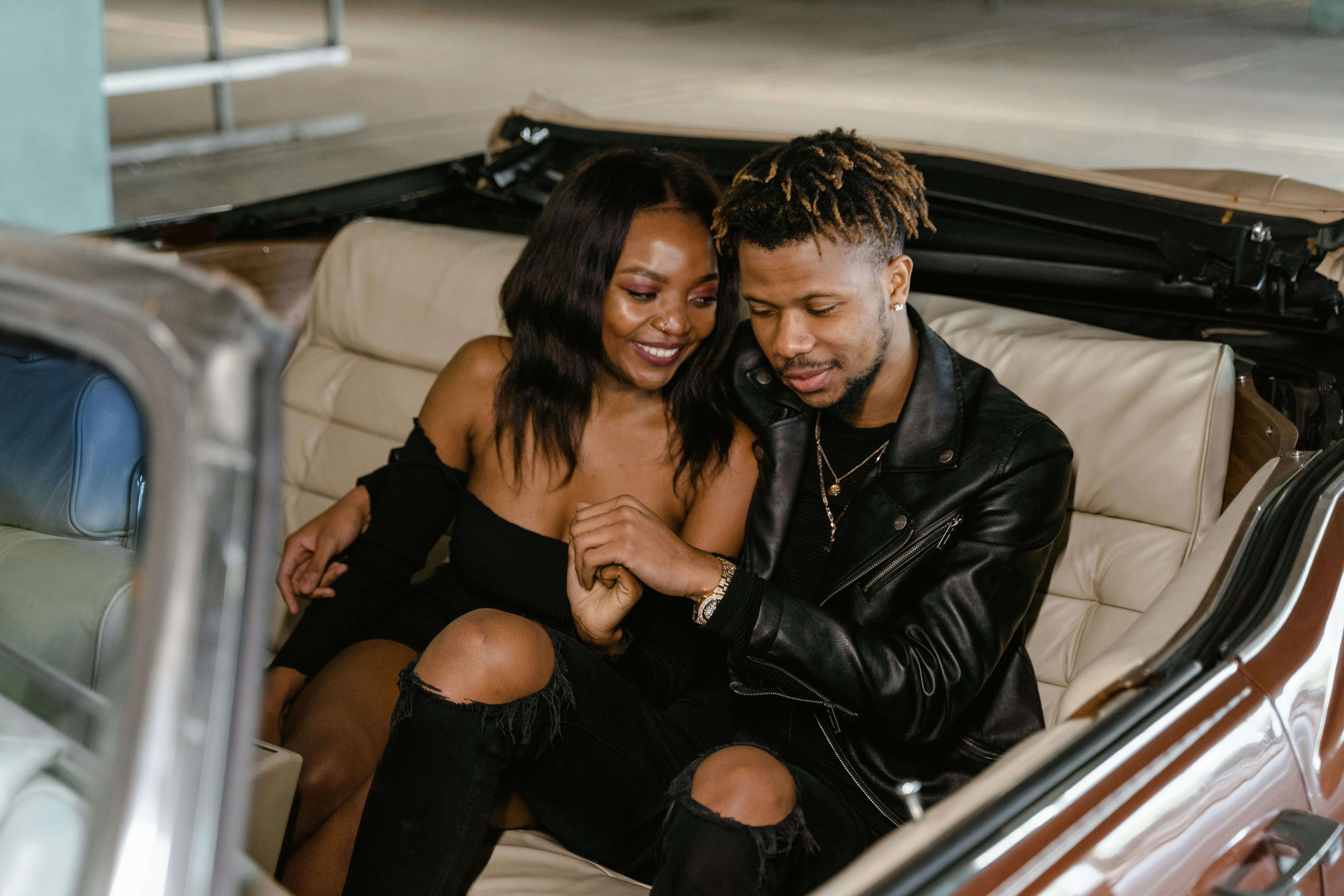 Young couple enjoying a romantic moment in a vintage convertible car.