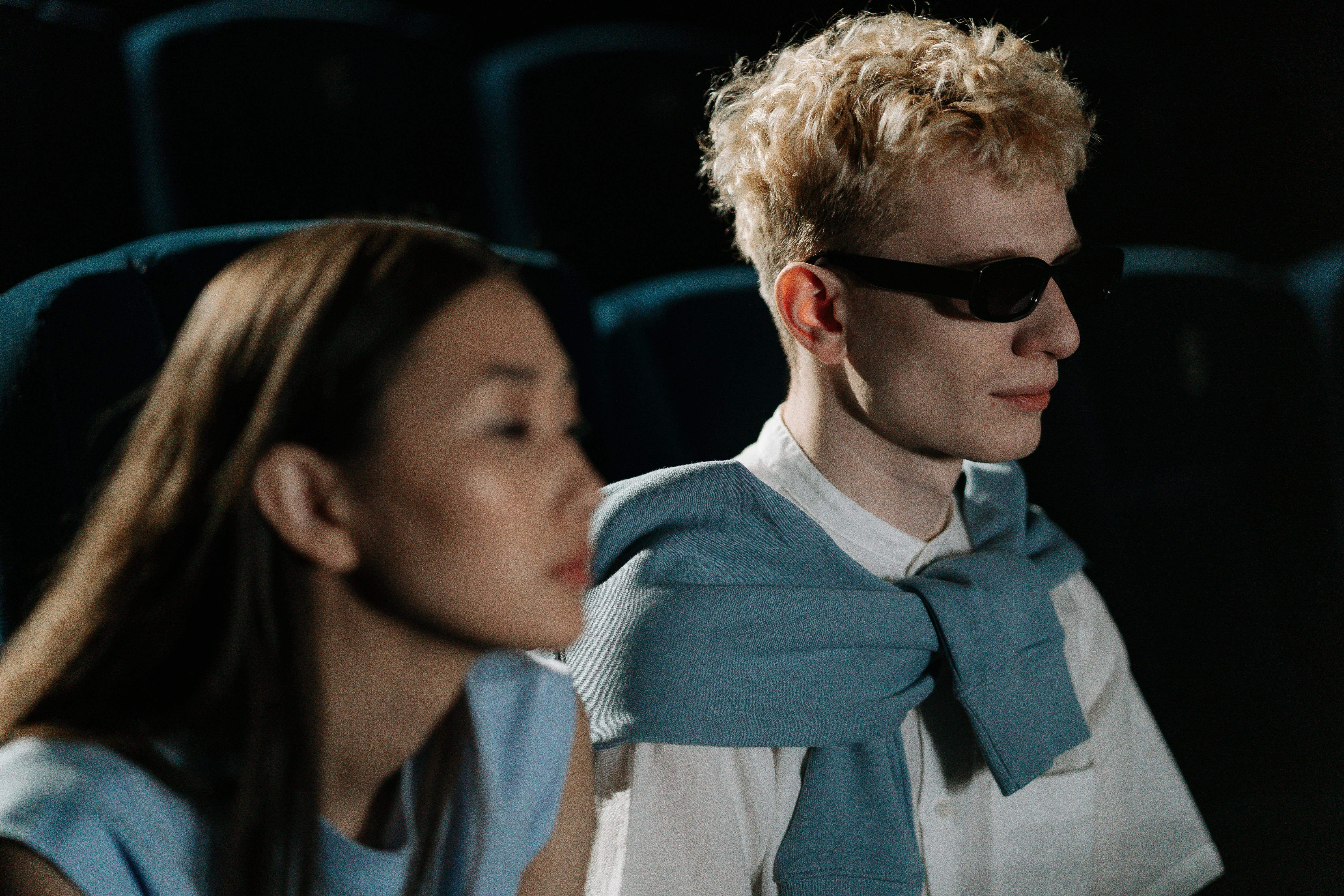 A visually impaired couple enjoys a cinema date, showcasing diversity.