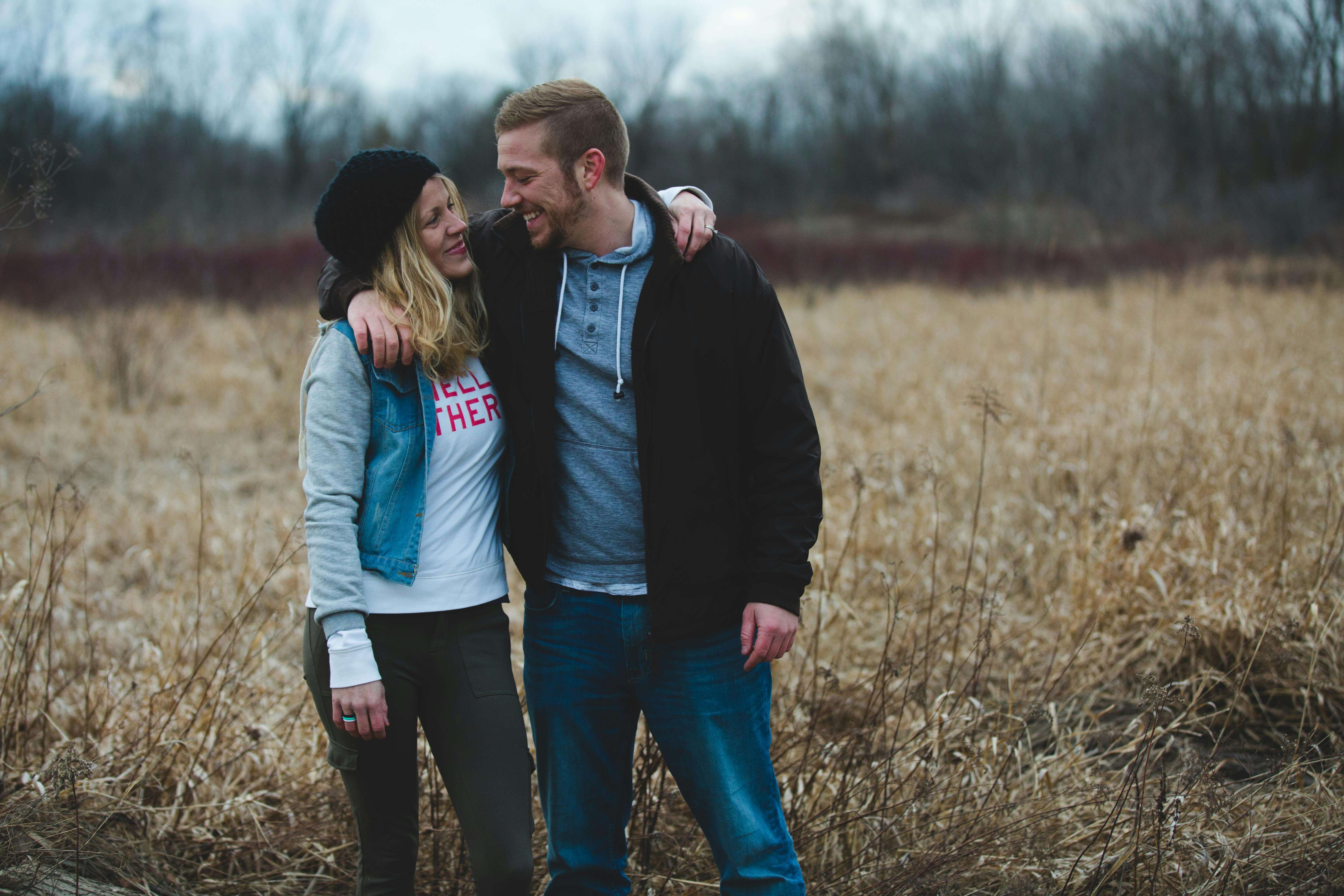 A loving couple enjoying a moment together in a serene, fall landscape.